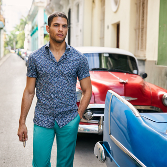 Man wearing patterned shirt and bright trousers in havana